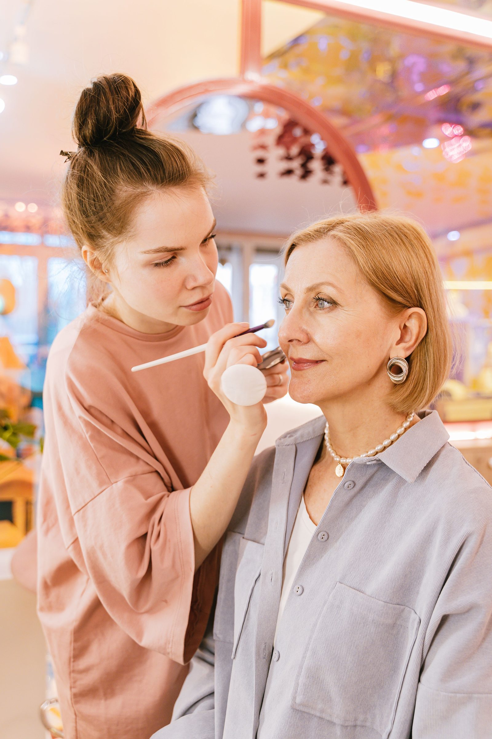 Estilista aplicando maquillaje a una clienta en un salón